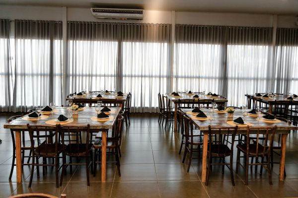 Rustic dining room setup with wooden tables and elegant tableware.