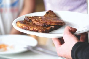 Juicy grilled pork chops served on a white plate, perfect for a tasty meal.