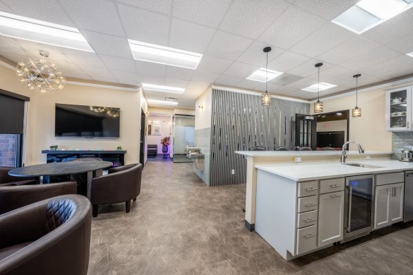 Two professionals interacting at a catered business event with coffee and fruit.